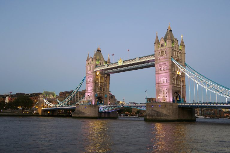 Tower Bridge, lit up at dusk. Discover what not to do when visiting the UK.