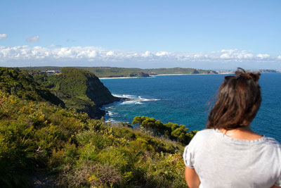 A person stands looking out at Dudley Beach. If you're looking for things to do in Lake Macquarie, you should definitely explore the area's walking trails.