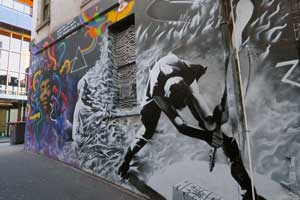 Street art of a man slamming a guitar on the ground. Looking at street art is a great idea for a quirky date in Melbourne.