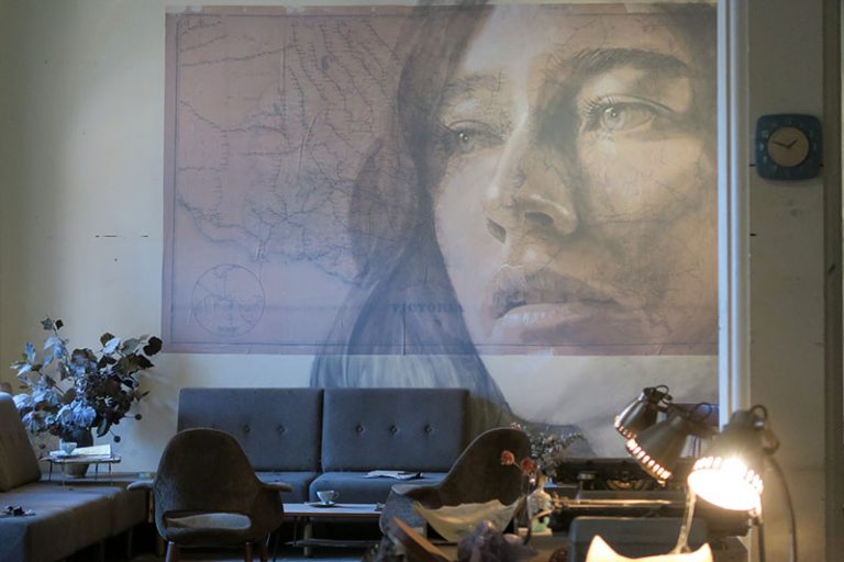 An office space installation, with a mural by Melbourne-based artist RONE on the wall. Discover unusual things to do in Melbourne.